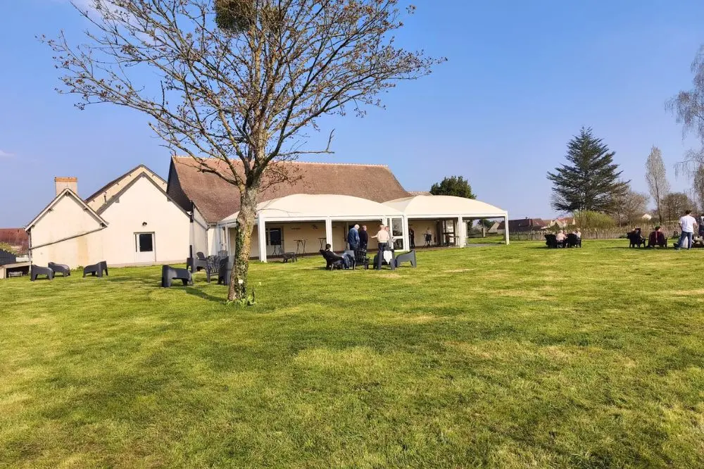 Vue extérieure du Domaine des 4S avec sa salle de réception, sa terrasse couverte et son vaste parc arboré.