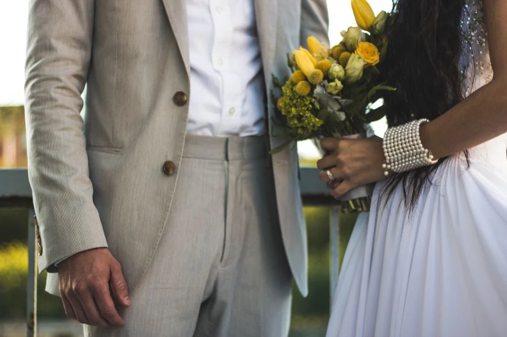 Couple de mariés tenant un bouquet de fleurs au Domaine des 4S près de Vendôme avant leur réception.