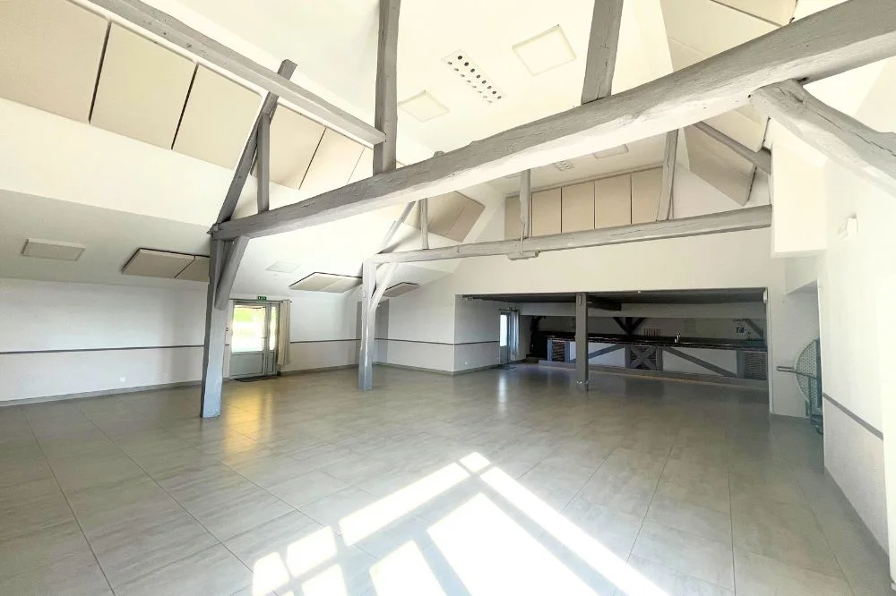Salle de réception avec poutres et dalles acoustiques au plafond